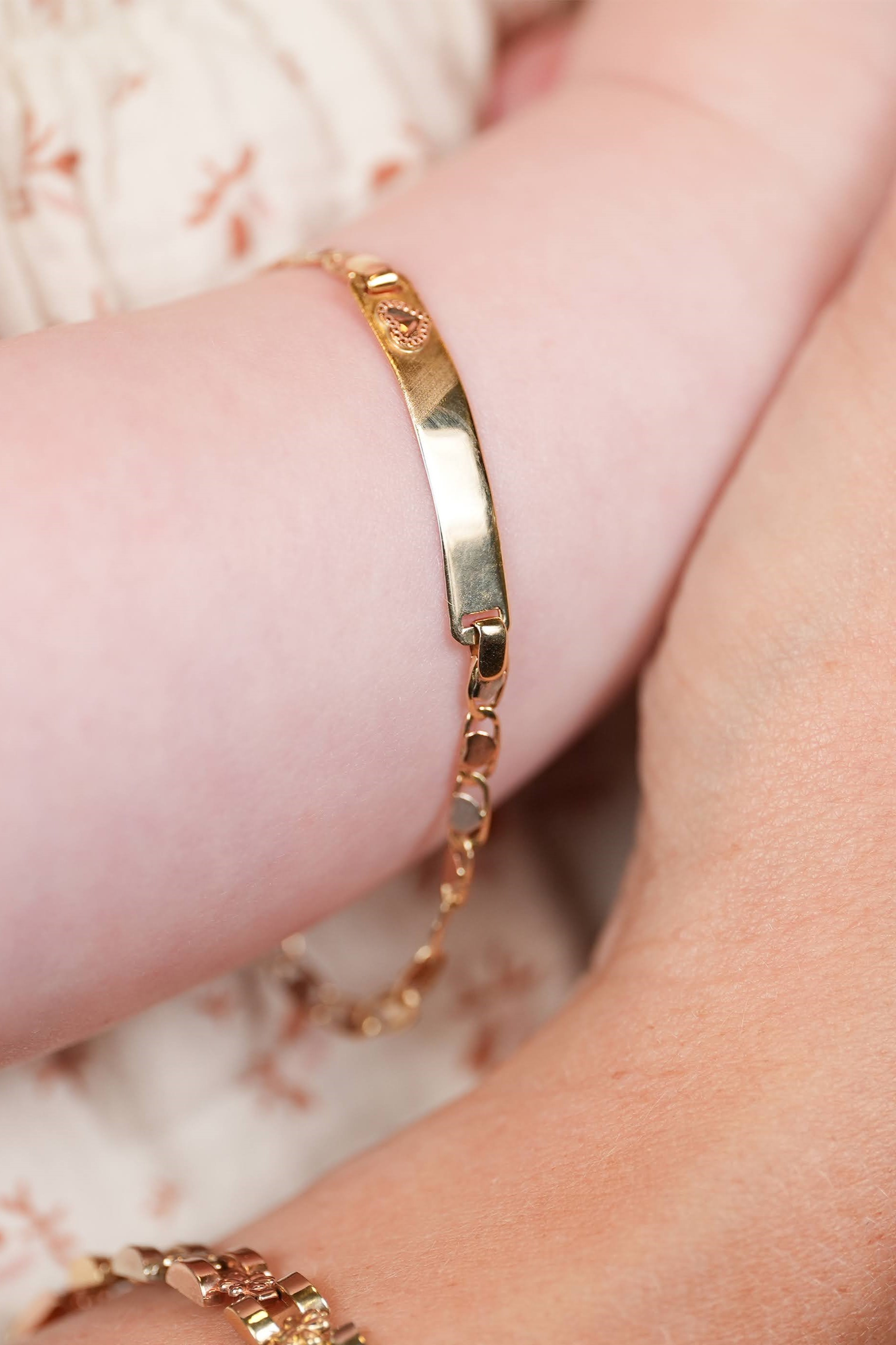 baby showcasing Don Roberto Jeweler's gold bracelet
